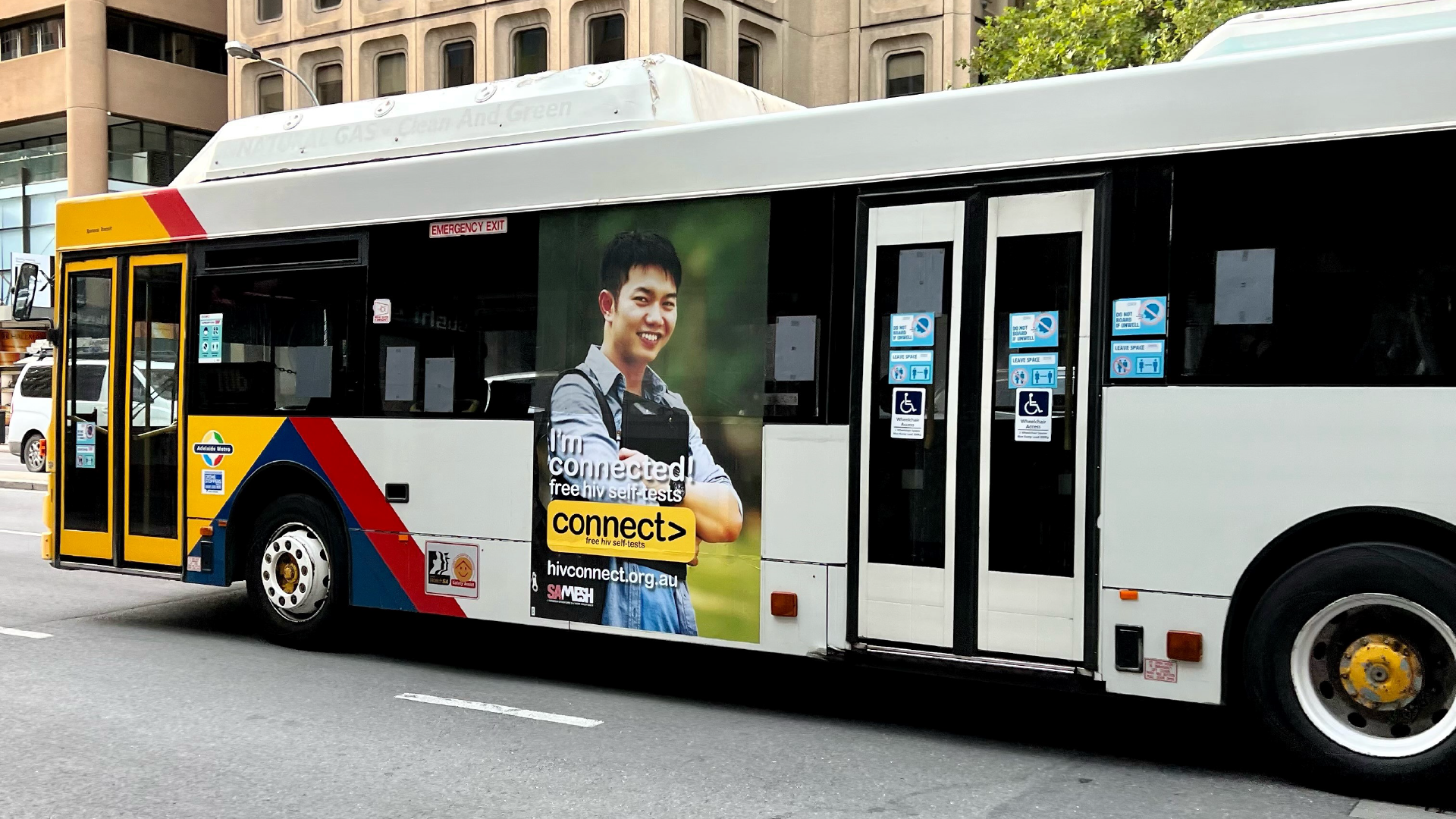 A public bus featuring an advertisement poster on its exterior